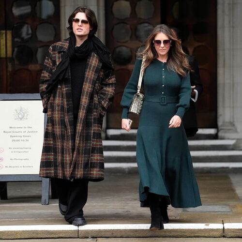 Elizabeth Hurley, right, leaves the Royal Courts of Justice on day four of the trial over allegations of unlawful information gathering brought against Associated Newspapers Limited, Thursday, Jan. 22, 2026, in London. (Jordan Pettitt/PA via AP)