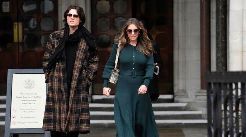Elizabeth Hurley, right, leaves the Royal Courts of Justice on day four of the trial over allegations of unlawful information gathering brought against Associated Newspapers Limited, Thursday, Jan. 22, 2026, in London. (Jordan Pettitt/PA via AP)