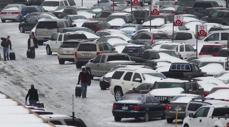 110110: travelers marches through the maze of snow covered cars in the South lot at Hartsfield-Jackson International Airport in Atlanta on Monday, Jan. 10, 2011. AirTran canceled all flights into and out of Atlanta for Monday. The airline said it made the decision "to ensure the safety of its crew members and passengers and to better prepare to return to normal operations on Tuesday." Delta said it canceled 1,450 Delta and Delta Connection flights system wide Monday due to the Atlanta snowstorm, about 25 percent of all flights scheduled for the day. That was on top of 500 flights Delta canceled Sunday night. Most Delta flights out of Atlanta are canceled. Customers scheduled to fly to, from or through Atlanta through Tuesday, and to certain Northeast cities through Thursday, can change their flights without fees. AirTran gave its customers the same offer. Delta said it notified customers directly when flights were canceled and urged all passengers to check and change flights at delta.com. John Spink jspink@ajc.com
