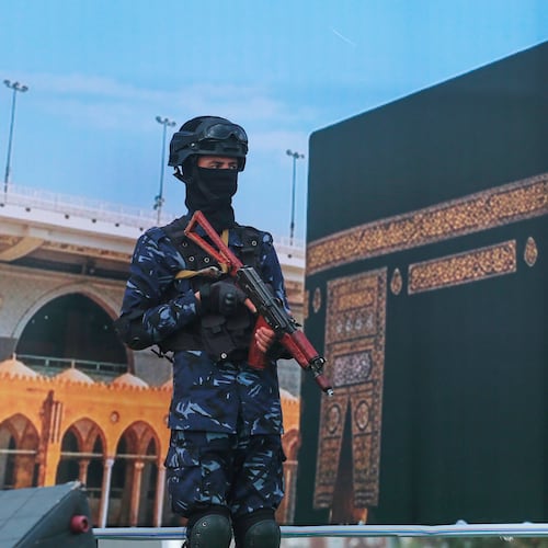 A soldier from Yemen's Houthi rebels stands in front of a giant banner of the Kaaba, during a rally to protest Saudi Arabia's accusation that the Houthis targeted Islam's holiest site in Sanaa, Yemen, Friday, Sept. 18, 2026. (AP Photo/Osamah Abdulrahman)