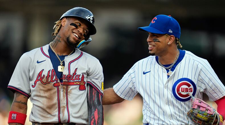 Chicago Cubs third baseman Christopher Morel, right, jokes with Atlanta Braves' Ronald Acuña Jr. after he pretended to tag him out after the first half of the first inning of a baseball game Tuesday, May 21, 2024, in Chicago. (AP Photo/Erin Hooley)