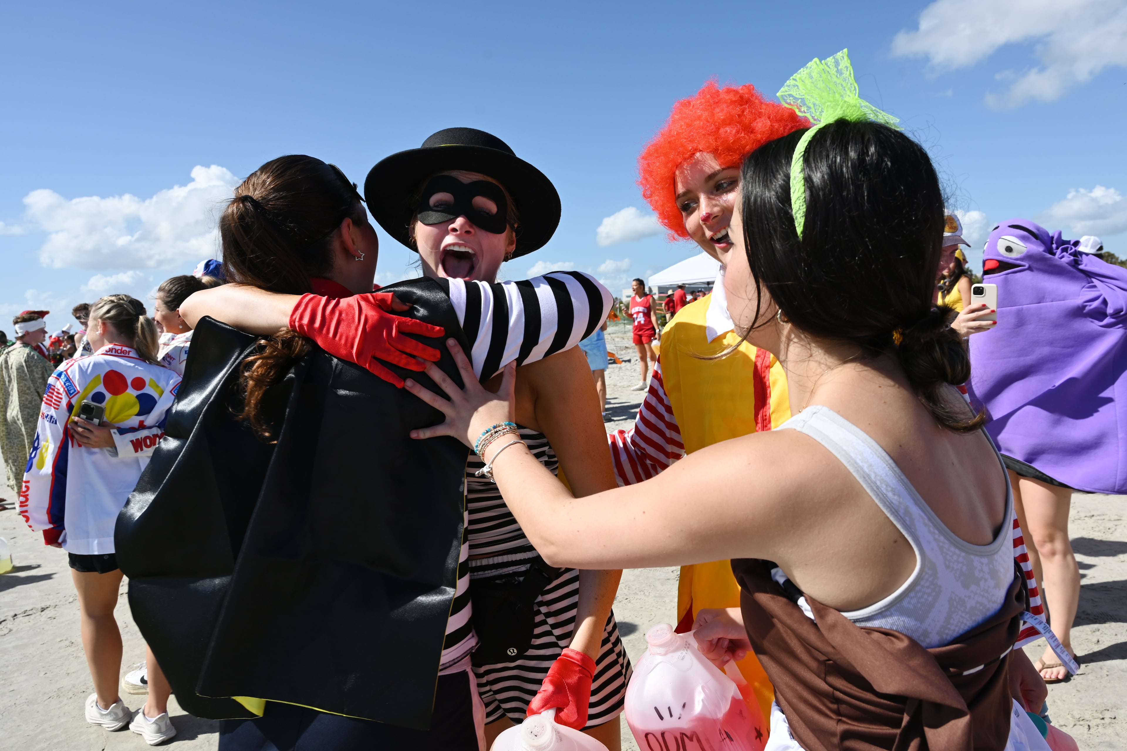UGA students with Halloween costumes greet each other  during the annual “Frat Beach” party for the weekend of the Georgia-Florida football game on St. Simons Island, Friday, November 1, 2024. On the weekend of the Georgia-Florida football game, St. Simons Island’s East Beach becomes “Frat Beach,” an open-air party teeming with thousands of college students. (Hyosub Shin / AJC)