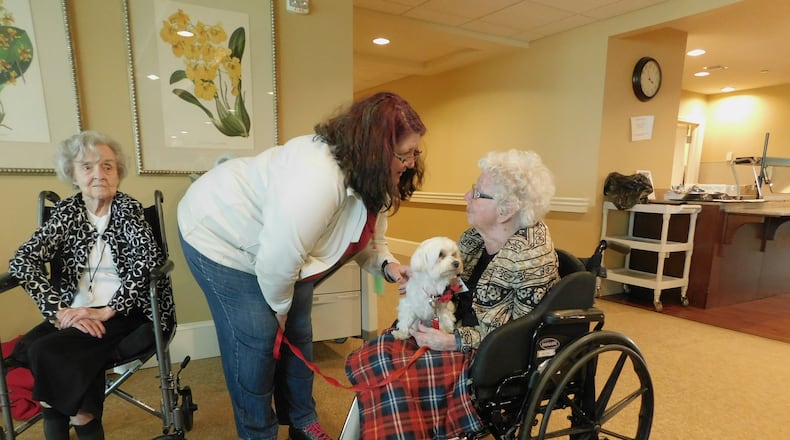 Happy Tails volunteer Arlene Sinanian visits with Louise McGuire (104 years old) while therapy dog Aiden looks on at Lenbrook senior community. Photo contributed by Lenbrook.