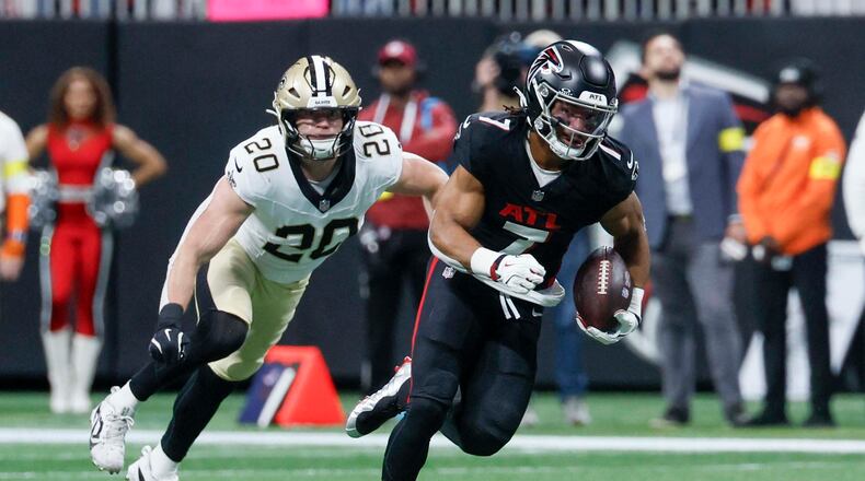 Falcons running back Bijan Robinson (right) rushes with the ball against the New Orleans Saints on Sunday, Jan. 4, 2026, at Mercedes-Benz Stadium in Atlanta. A first-round pick in 2023, Robinson has been electric since coming out of Texas. (Miguel Martinez/AJC)