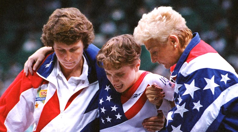 American Kerri Strug (middle) is helped after her final vault after hurting herself during the last routine in the team competition at the Georgia Dome. (AJC Staff Photo/Rich Addicks)
