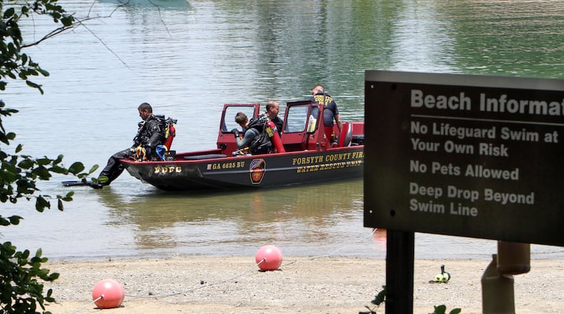 Forsyth County divers prepare to search the swimming area of Buford Dam Park on Lake Lanier on Sunday. A man disappeared there after a church baptism that was conducted in the lake.