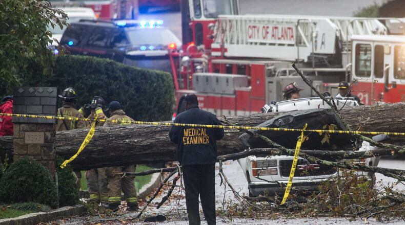 A medical examiner and Atlanta firefighters work a scene where a driver was killed after he drove his vehicle into a tree that fell on Woodhaven Road in Buckhead, Monday, Nov. 9, 2015. BRANDEN CAMP/SPECIAL