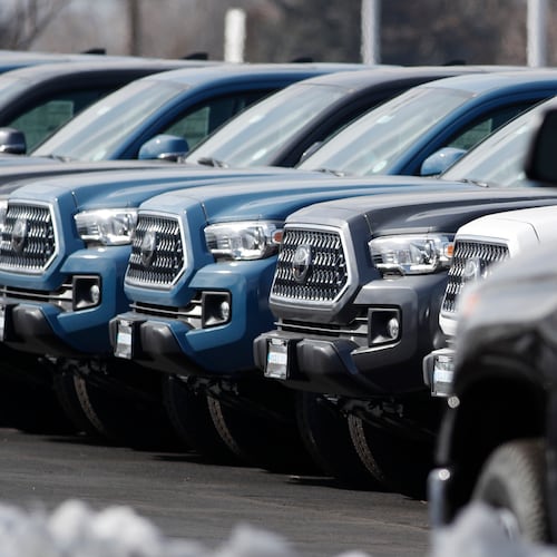 A long row of 2019 Tacoma pickup trucks sits at a Toyota dealership in Lakewood, Colo. Toyota has settled a lawsuit from the wife of an Atlanta man who died of carbon monoxide poisoning after unwittingly leaving his 2017 Tacoma idling in the garage attached to their home. Toyota implemented automatic engine shut-off in its vehicles in 2020. (David Zalubowski/AP 2019)
