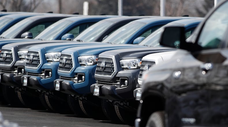 A long row of 2019 Tacoma pickup trucks sits at a Toyota dealership in Lakewood, Colo. Toyota has settled a lawsuit from the wife of an Atlanta man who died of carbon monoxide poisoning after unwittingly leaving his 2017 Tacoma idling in the garage attached to their home. Toyota implemented automatic engine shut-off in its vehicles in 2020. (David Zalubowski/AP 2019)