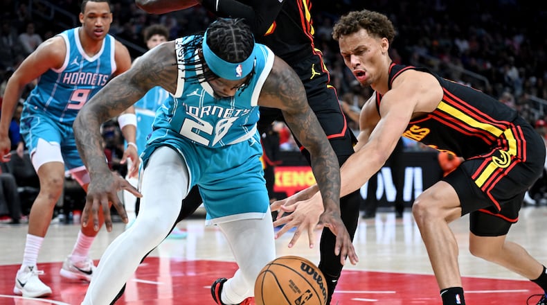 Charlotte Hornets guard Marcus Garrett (28) and Atlanta Hawks guard Dyson Daniels (5) fight for a loose ball during the second half in an NBA basketball game at State Farm Arena, Wednesday, March 12, 2025, in Atlanta. Atlanta Hawks won 123-110 over Charlotte Hornets. (Hyosub Shin / AJC)