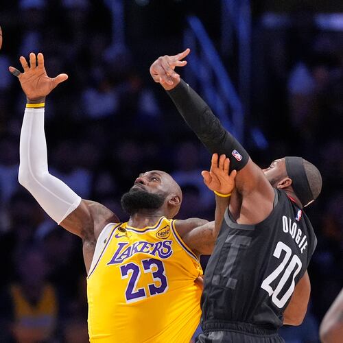 Los Angeles Lakers forward LeBron James, left, takes a pass as Houston Rockets guard Josh Okogie defends during the first half in Game 1 of a first-round NBA playoffs basketball series Saturday, April 18, 2026, in Los Angeles. (AP Photo/Mark J. Terrill)