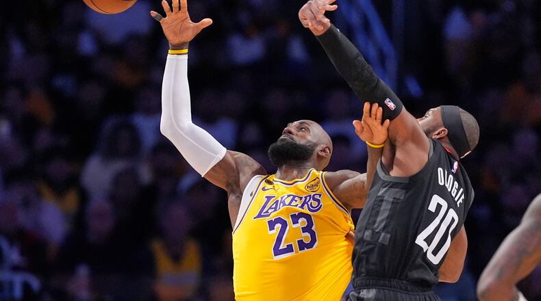 Los Angeles Lakers forward LeBron James, left, takes a pass as Houston Rockets guard Josh Okogie defends during the first half in Game 1 of a first-round NBA playoffs basketball series Saturday, April 18, 2026, in Los Angeles. (AP Photo/Mark J. Terrill)