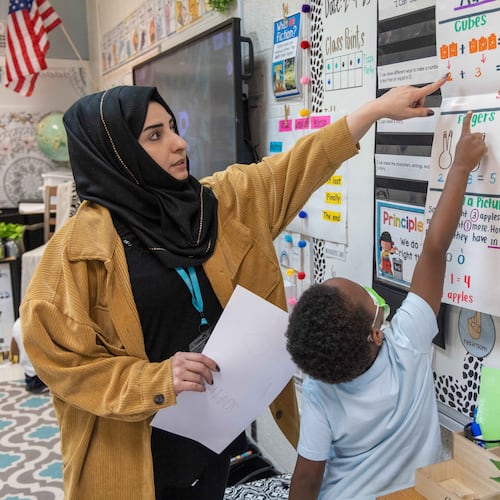 Shakila Amiaq (left), a recent Afghan refugee who is studying to become a teacher, helps a kindergarten student at the International Community School in Clarkston. (Phil Skinner for The Atlanta Journal-Constitution)