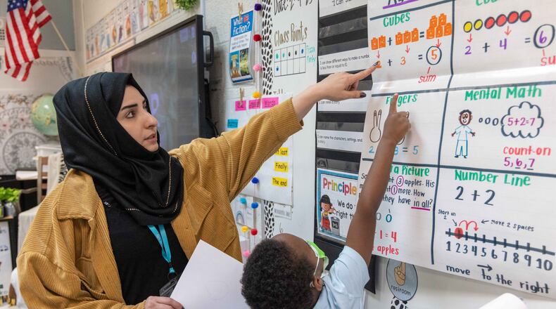 Shakila Amiaq (left), a recent Afghan refugee who is studying to become a teacher, helps a kindergarten student at the International Community School in Clarkston. (Phil Skinner for The Atlanta Journal-Constitution)