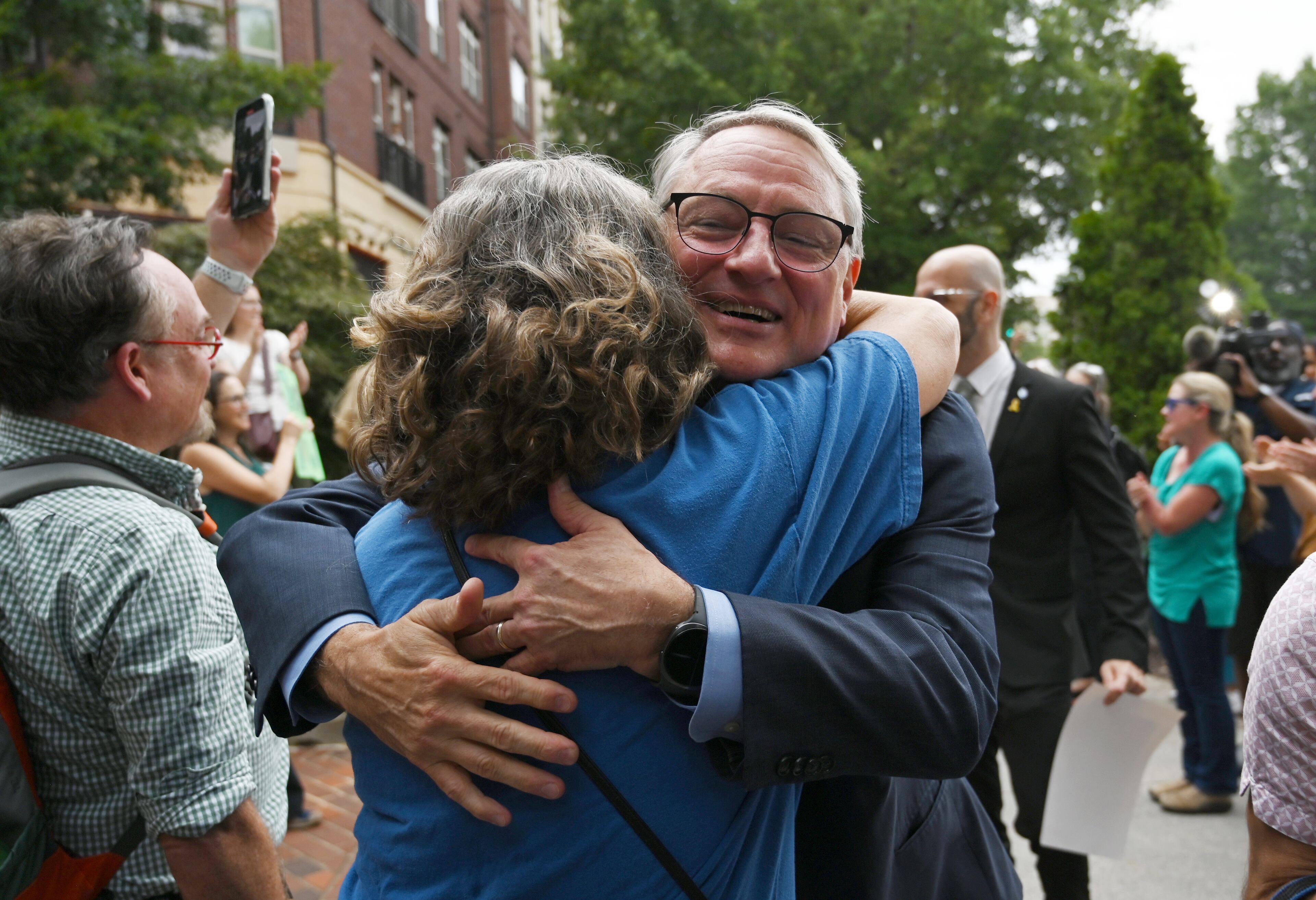 Dr. Daniel Jernigan, leader of the agency's work on emerging infectious diseases, gets hugged as CDC staff and supporters gather to rally for departing leaders outside the CDC headquarters, Thursday, August 28, 2025, in Atlanta. Top leaders who resigned their positions at the US Centers for Disease Control and Prevention after the ouster of the agency’s director were escorted out of the building Thursday morning. (Hyosub Shin / AJC)