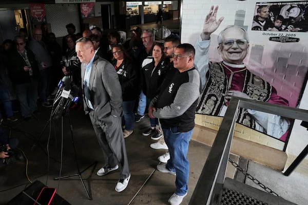Brooks Boyer, left, Chicago White Sox Senior Vice President, Chief Revenue and Marketing Officer talks to media at a news conference for Chicago White Sox commemorate fandom of Pope Leo XIV with Graphic installation at Rate Field before a baseball game between the Seattle Mariners and the Chicago White Sox in Chicago, Monday, May 19, 2025. (AP Photo/Nam Y. Huh)