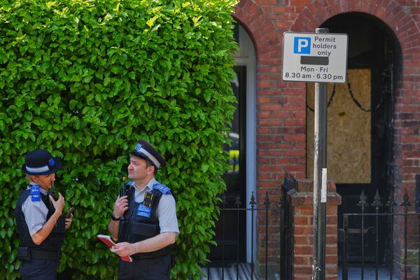 Police Community Support Officers stand near the fire damaged doorway of a house belonging to British Prime Minister Keir Starmer in Kentish Town in London, Tuesday, May 13, 2025. (AP Photo/Kirsty Wigglesworth)