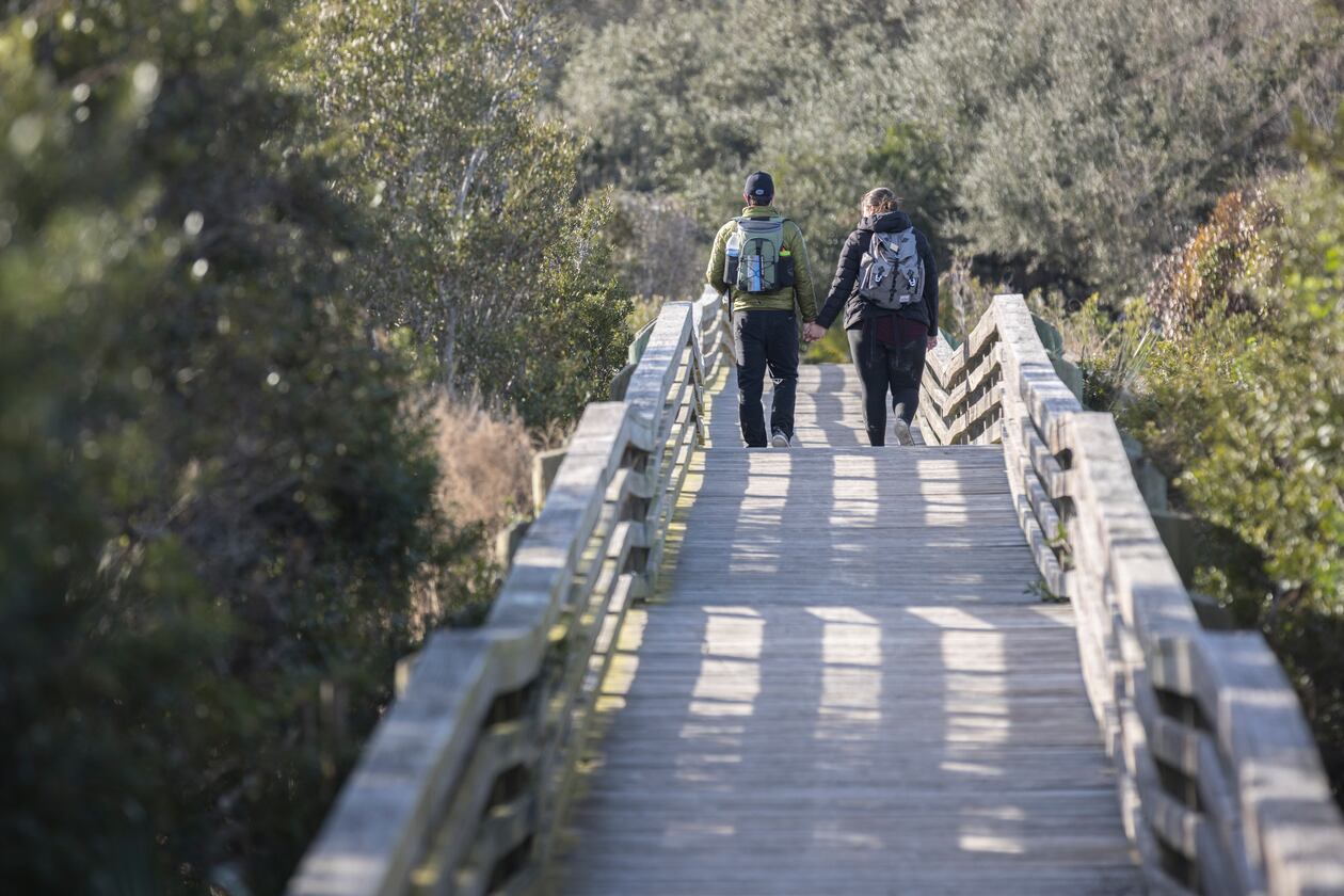 A couple takes the Sea Camp boardwalk as they spend their wedding anniversary enjoying the national seashore in Cumberland Island. The island is big enough to welcome both the public visitor and the private property holder to enjoy its beauty, guest columnist Sam Candler writes. (Stephen B. Morton/AJC 2022)