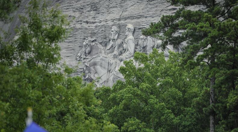 Confederate flag sympathizers march past Stone Mountain at Saturday's rally. John Amis/AJC
