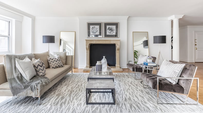 A large gray area rug helps ground this large living room. Gray chairs complete the look. (Design Recipes)