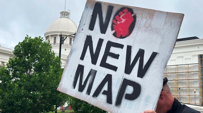 FILE -A demonstrator holds up a sign outside the Alabama Statehouse in Montgomery, Ala., on May, 7 2026. (AP Photo/Kim Chandler, File)