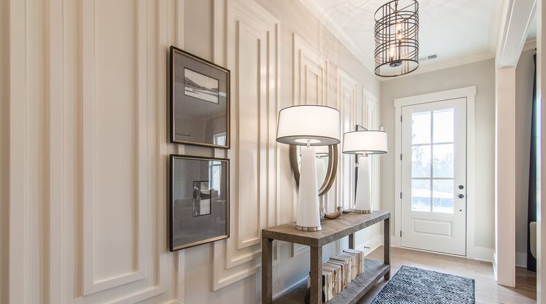 Edward Andrews Homes uses picture framing wainscoting in a home in Alpharetta’s Larkspur community as a focal point in the foyer. Layers of trim painted the same color as the wall brings depth to the foyer. CONTRIBUTED BY: Edward Andrews Homes