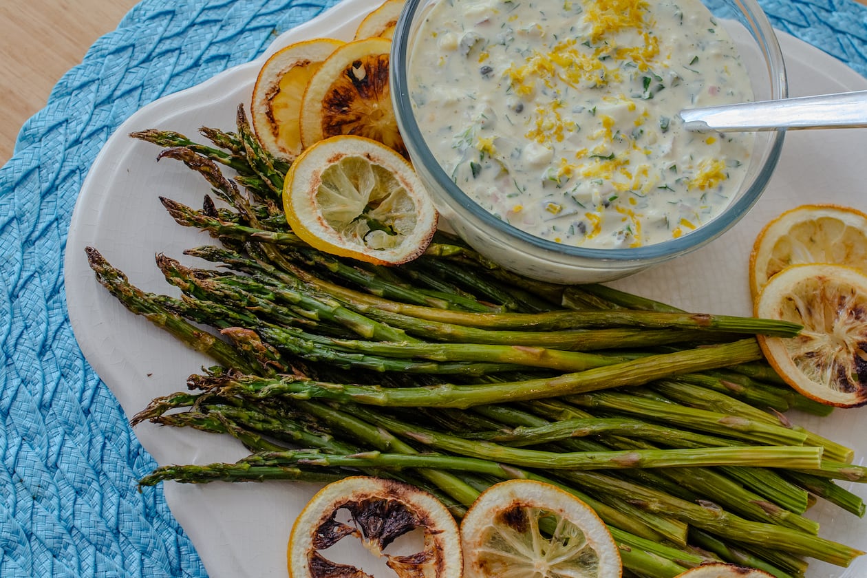 Blistered asparagus with bold and zesty Weeknight Sauce Gribiche makes an easy side dish or light supper. (Virginia Willis for The Atlanta Journal-Constitution)
