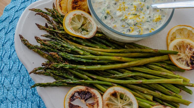 Blistered asparagus with bold and zesty Weeknight Sauce Gribiche makes an easy side dish or light supper. (Virginia Willis for The Atlanta Journal-Constitution)