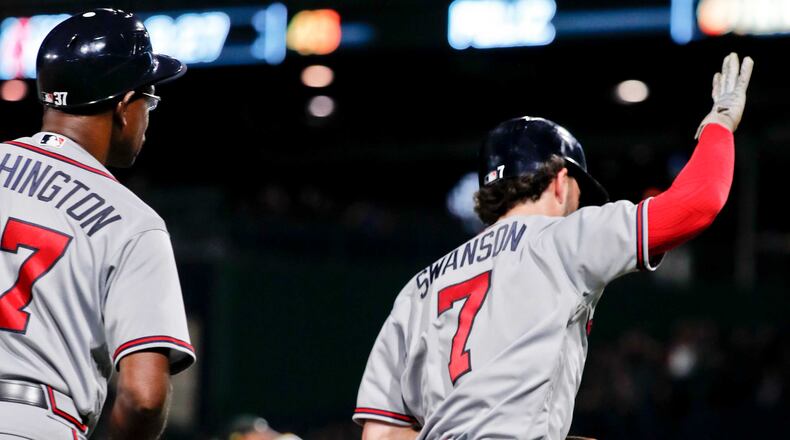 Braves' Dansby Swanson (7) celebrates after passing third base coach Ron Washington, left, as he rounds the bases after hitting a two-run home run off Pittsburgh Pirates relief pitcher Michael Feliz, center, in the seventh inning of a baseball game, Tuesday, Aug. 21, 2018, in Pittsburgh. (AP Photo/Keith Srakocic)