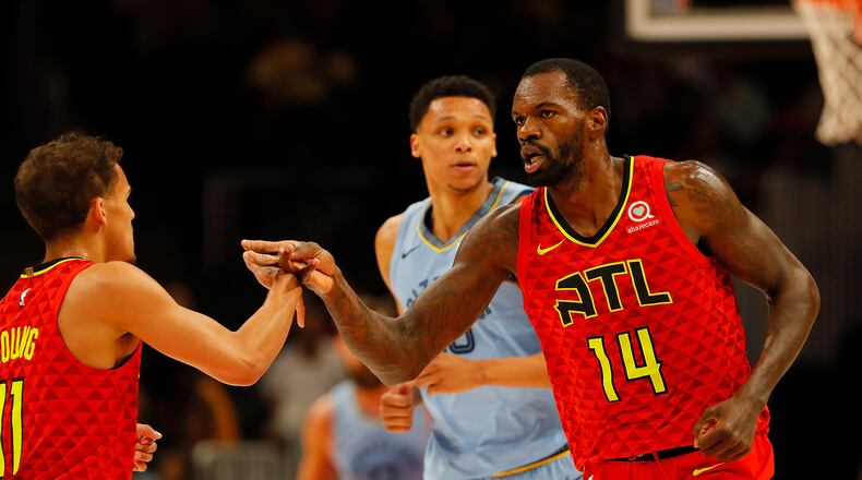 Dewayne Dedmon reacts with Trae Young after their connection on a basket in the first half. Young finished with 22 points and eight assists. (Photo by Kevin C. Cox/Getty Images)
