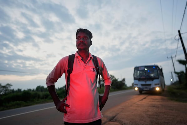 Vilvaraj Vinothan, who works for a demining agency, stands by the main highway with runs across the former battlefields, in Mankulam, Sri Lanka, Wednesday, April 2, 2025. (AP Photo/Eranga Jayawardena)
