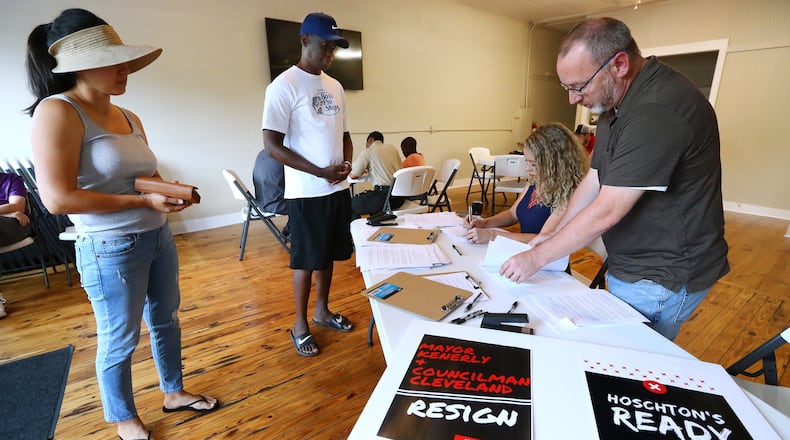 Local residents Erica & Anthony Osula (from left) fill out ethics complaints with Jackson County Republican Chair Katie Griffin and Democratic Chair Pete Fuller against Hoschton Mayor Theresa Kenerly and Councilman Jim Cleveland in May. Kenerly came under fire for withholding a candidate from consideration for city administrator because he is black. Cleveland, a Kenerly supporter, said Christian beliefs prevented him from sanctioning interracial marriage. The two politicians are now the target of a recall effort. CURTIS COMPTON/CCOMPTON@AJC.COM