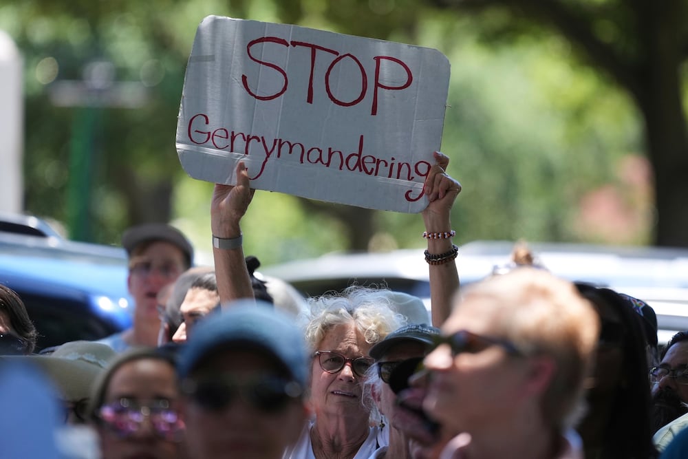 A woman holds a sign during a rally to protest the redistricting hearings at the state Capitol in Austin, Texas, on Thursday.