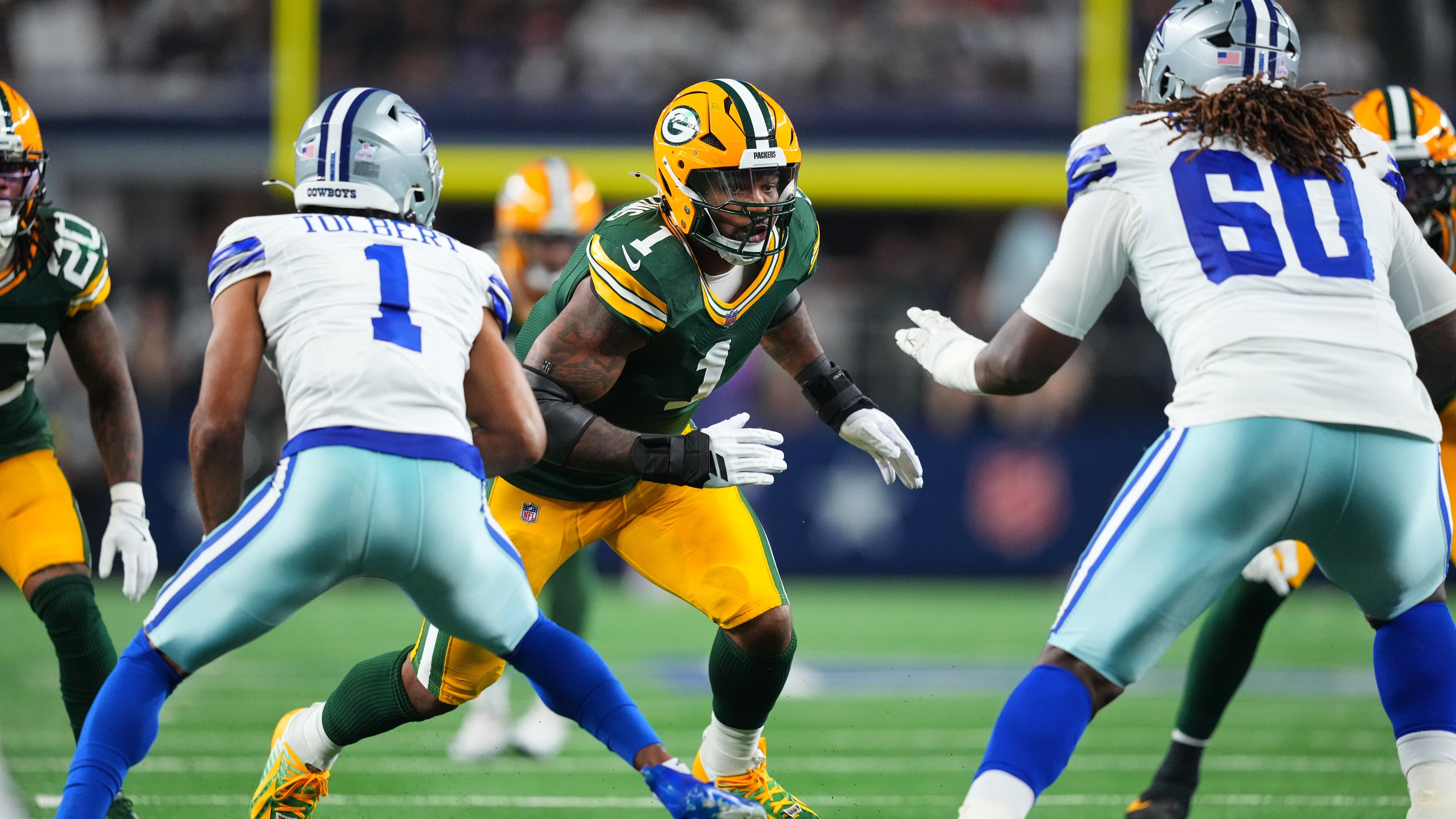 Green Bay Packers defensive end Micah Parsons (1) rushes as Dallas Cowboys' Jalen Tolbert (1) and Tyler Guyton (60) defend in the first half of an NFL football game Sunday, Sept. 28, 2025, in Arlington, Texas. (AP Photo/Julio Cortez)