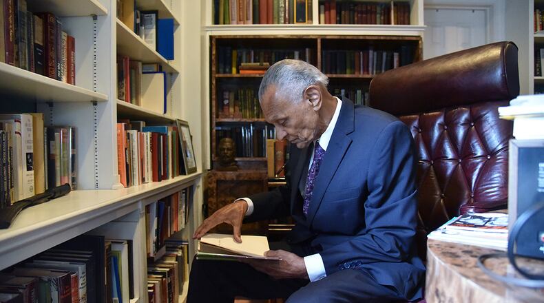 July 25, 2017 Atlanta - C.T. Vivian looks through a book at his home library on Tuesday, July 25, 2017. The National Monuments Foundation will be acquiring and managing the world-class library of Atlanta Civil Rights icon, C.T. Vivian. The library will be housed in the new Cook Park in Vine City. Vivian lived in the same Vine City neighborhood that will border Cook Park where his library is to be constructed under a 101-foot Peace Column. The 6,000 volume C.T. Vivian Library is one of the most impressive private collections in the city. HYOSUB SHIN / HSHIN@AJC.COM
