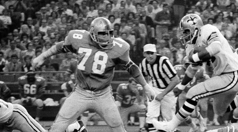 New Orleans Saints running back James Ford (28) jumps into the arms of a waiting  Houston defensive tackle Mike Tilleman (78) on Oct. 3, 1971, in Houston. (Ed Kolenovsky/AP)