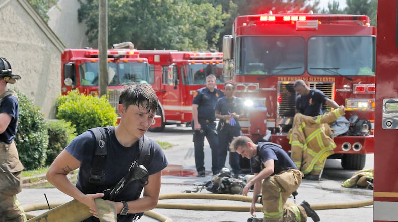 DeKalb firefighters do their best to keep cool in hot, humid afternoon temperatures as they battle an apartment fire on July 25, 2017.  BOB ANDRES  /BANDRES@AJC.COM
