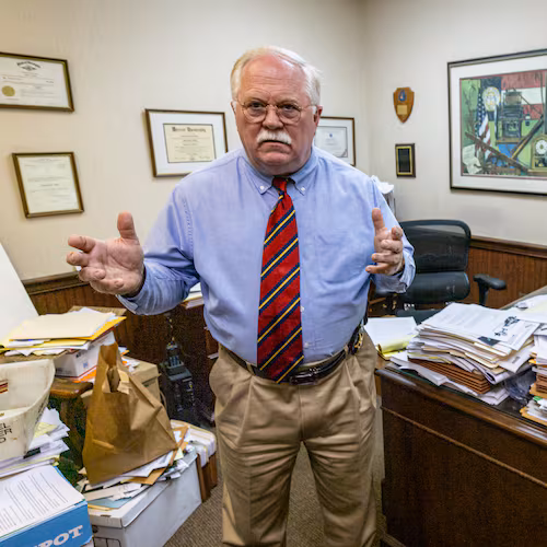 Putnam County Sheriff Howard Sills stands in his office surrounded by case files. The veteran lawman continues to hunt for leads in the unsolved 2014 slayings of Shirley and Russell Dermond. (Steve Schaefer/AJC 2024)