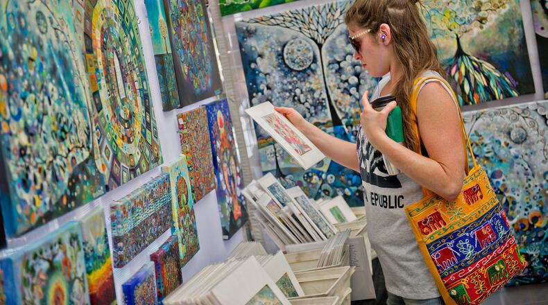 Leah Klatzker looks at paintings in Manami Lingerfelt's booth during the May-retta Daze Arts & Craft Festival at Glover Park in Marietta on Sunday, May 4, 2014.
