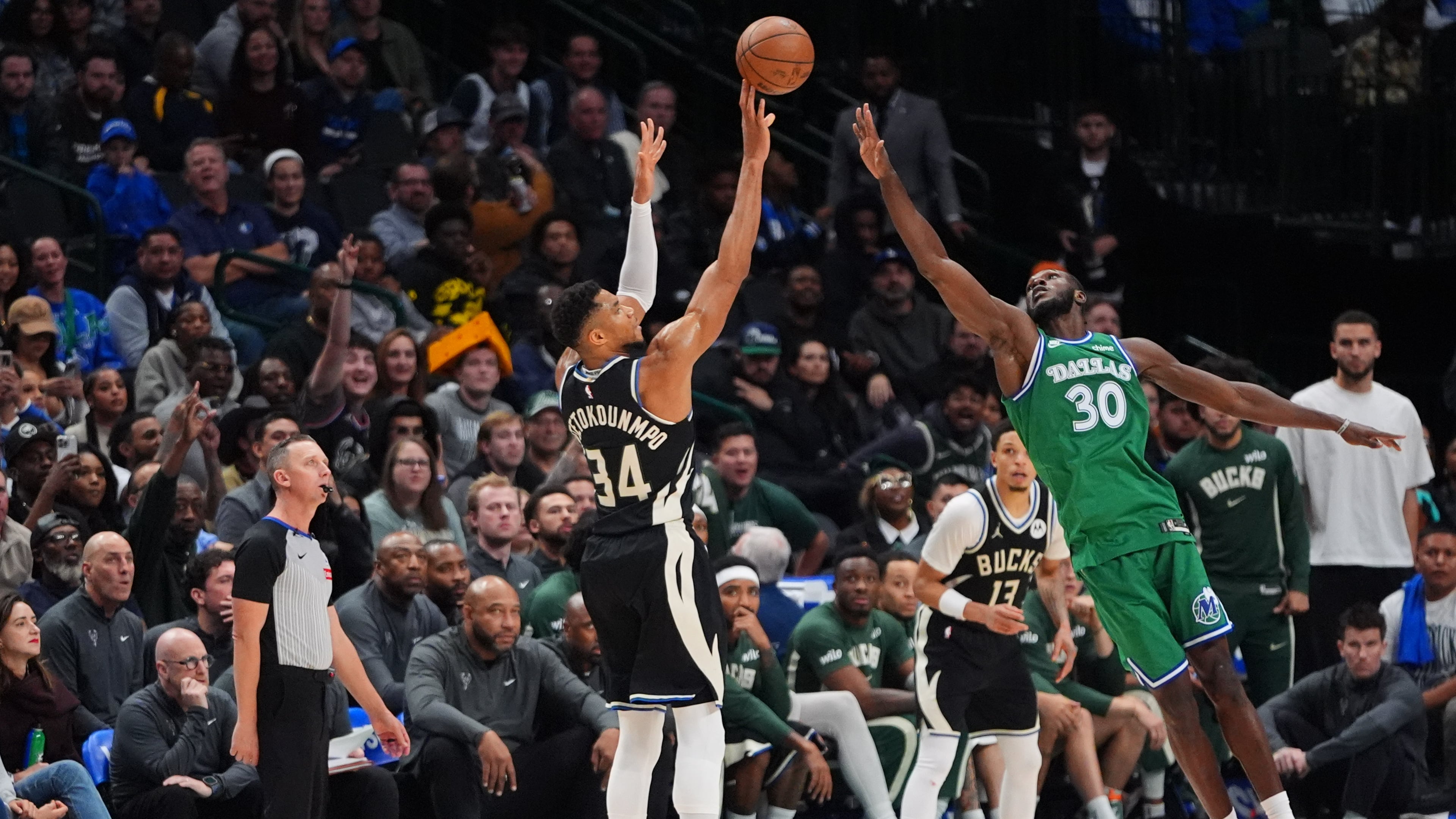 Milwaukee Bucks forward Giannis Antetokounmpo (34) shoots a three-pointer against Dallas Mavericks center Moussa Cisse (30) during the second half of an NBA basketball game in Dallas, Monday, Nov. 10, 2025. (AP Photo/LM Otero)