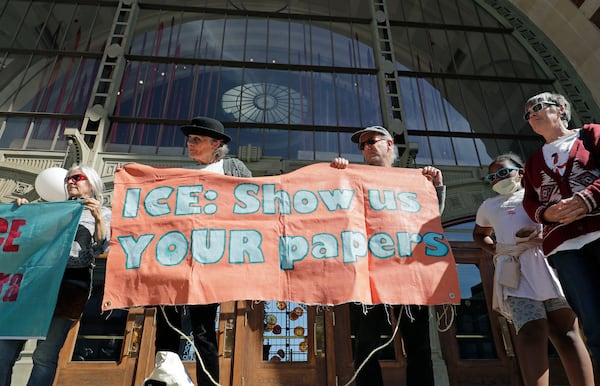 FILE - Nancy Farrell, second from left, and John Carlton, third from left, hold a sign as they stand outside the federal courthouse in Tacoma Wash., Sept. 18, 2018. (AP Photo/Ted S. Warren, file)