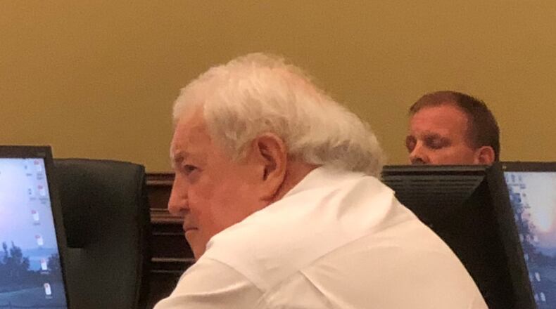Buford City Schools Board of Education Chairman Phillip Beard listens as residents address the board. Some in the audience asked that he step down as chairman, a position he’s held for 44 years. ARLINDA SMITH BROADY/AJC