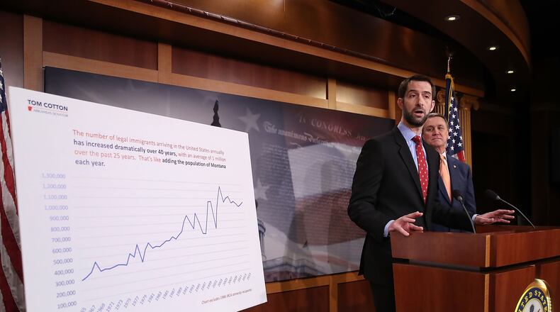 U.S. Sens. Tom Cotton, R-Ark., and David Perdue, R-Ga., speak to the media during a news conference Tuesday on Capitol Hill. Cotton and Perdue unveiled immigration legislation they say is aimed at cutting in half the number of green cards issued annually by the U.S. (Photo by Mark Wilson/Getty Images)