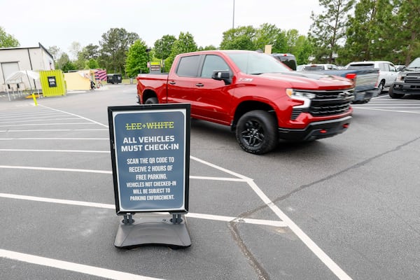 Cars pass by a sign in Lee + White Commercial District indicating parking rules, as seen on Sunday, April 19, 2026. (Miguel Martinez/AJC)
