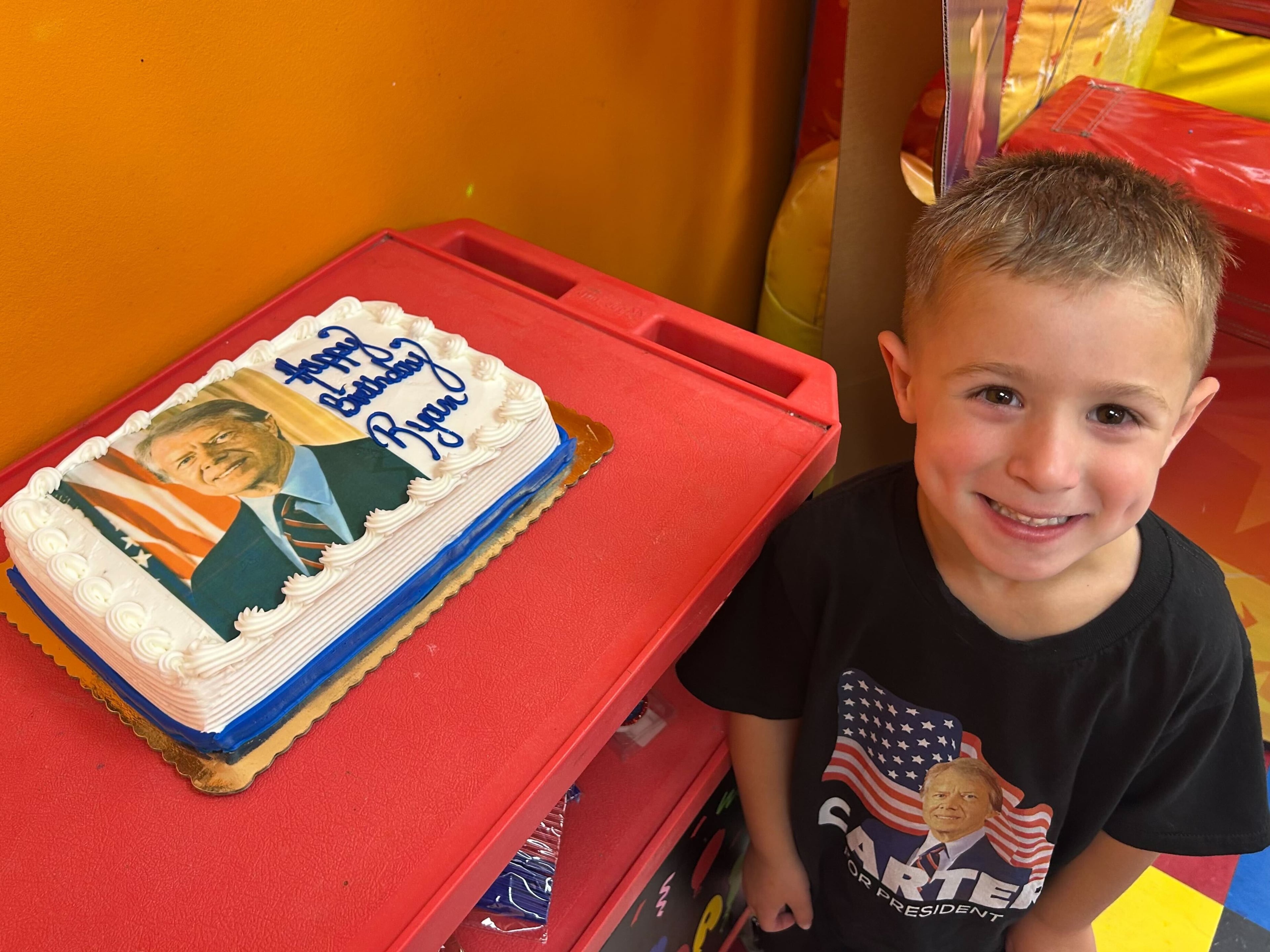 A New Jersey boy named Ryan, sporting his "Carter for President" T-shirt, stands next to his Jimmy Carter-themed birthday cake at the party his mother, Lauren Ramos, planned for him. (Courtesy)