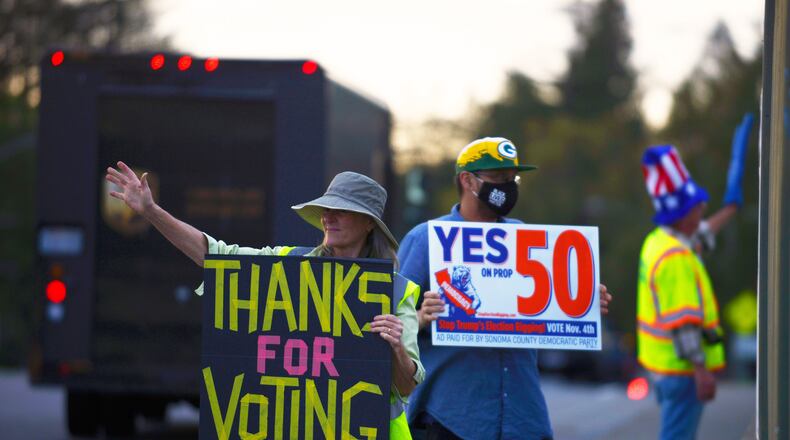 From left: Jennifer York, Zac Britton, and George Reed encourage passing motorists to vote Yes on Prop 50 along Bicentennial Way in Santa Rosa, Calif., on Monday Nov. 3, 2025. (Alvin A.H. Jornada/San Francisco Chronicle via AP)