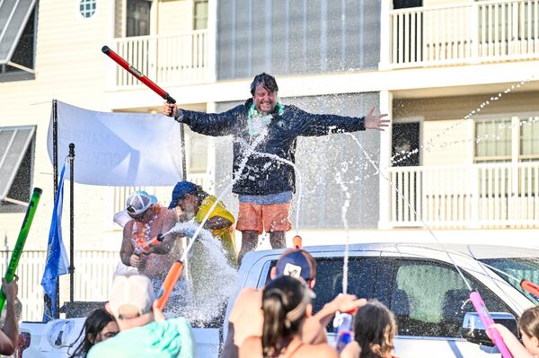 A parade participant accepts his watery fate during the Beach Bum Parade on Tybee Island. (Sarah Peacock for the AJC) 