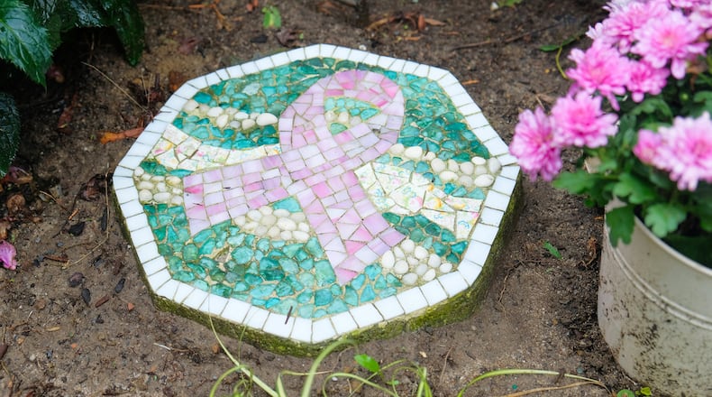 A breast cancer ribbon mosaic tile, handmade by Vera Capogna, a breast cancer survivor, decorates her pink themed garden. (Daniel Brennan)
