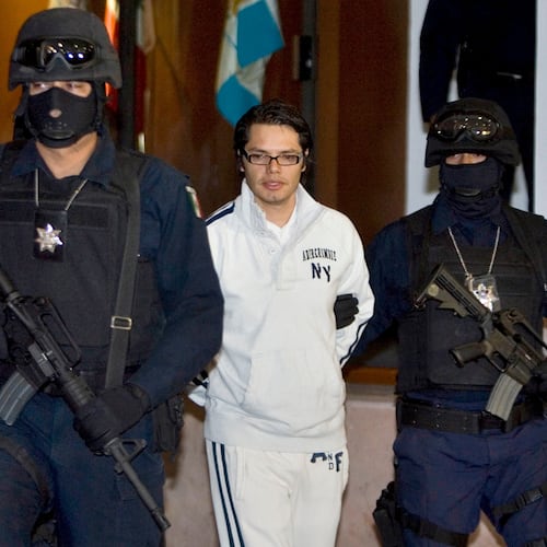 FILE - Federal police officers escort Vicente Carrillo Leyva, the alleged second-in-command of the Juarez Cartel, during his presentation to the media in Mexico City, April 2, 2009. (AP Photo/Eduardo Verdugo, File)