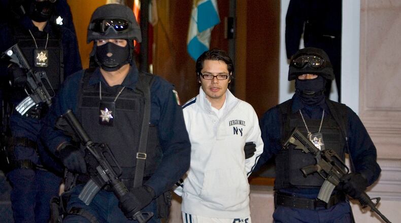 FILE - Federal police officers escort Vicente Carrillo Leyva, the alleged second-in-command of the Juarez Cartel, during his presentation to the media in Mexico City, April 2, 2009. (AP Photo/Eduardo Verdugo, File)